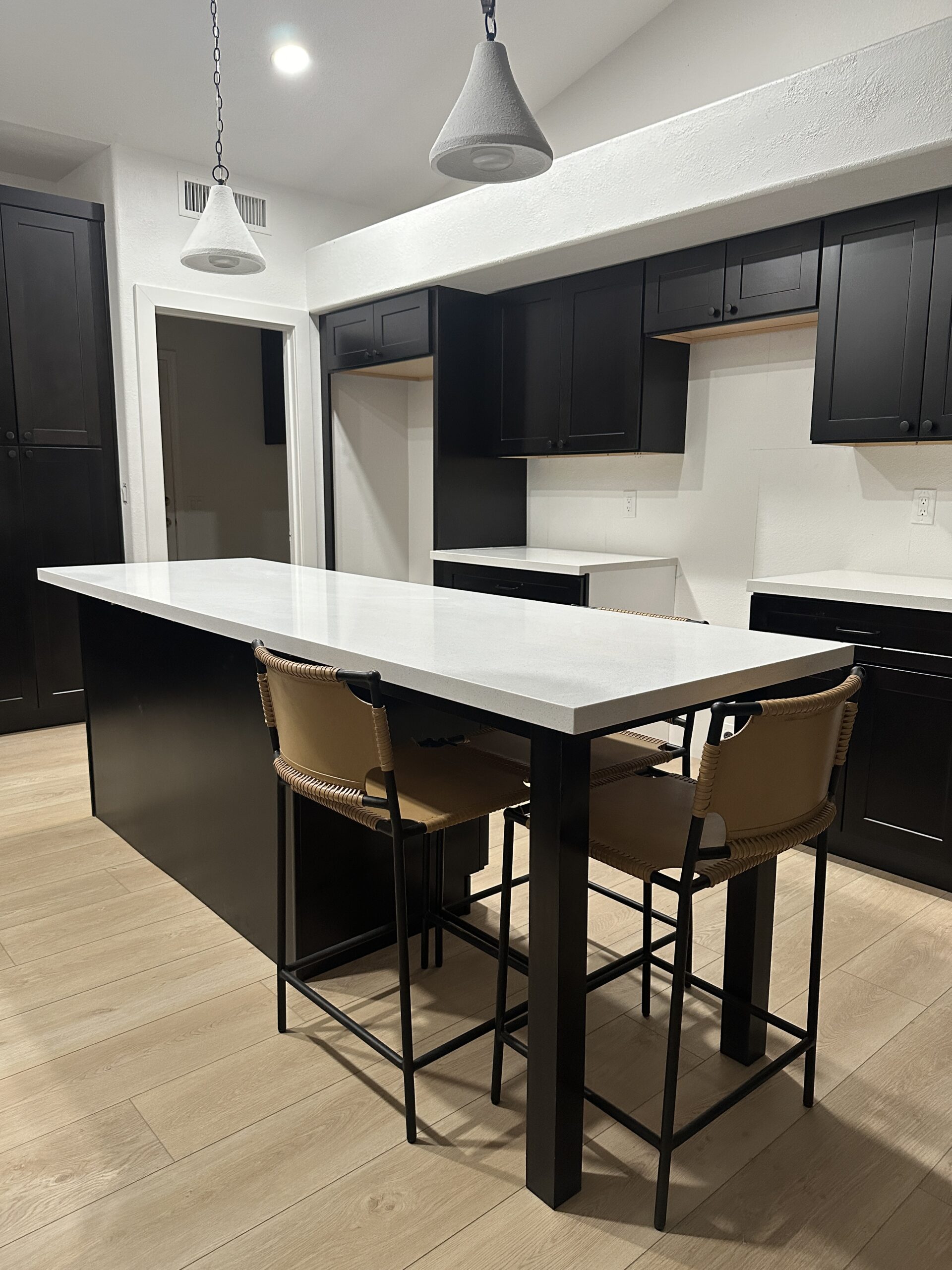 Kitchen remodel with dark cabinetry and an island by T26 Design Build