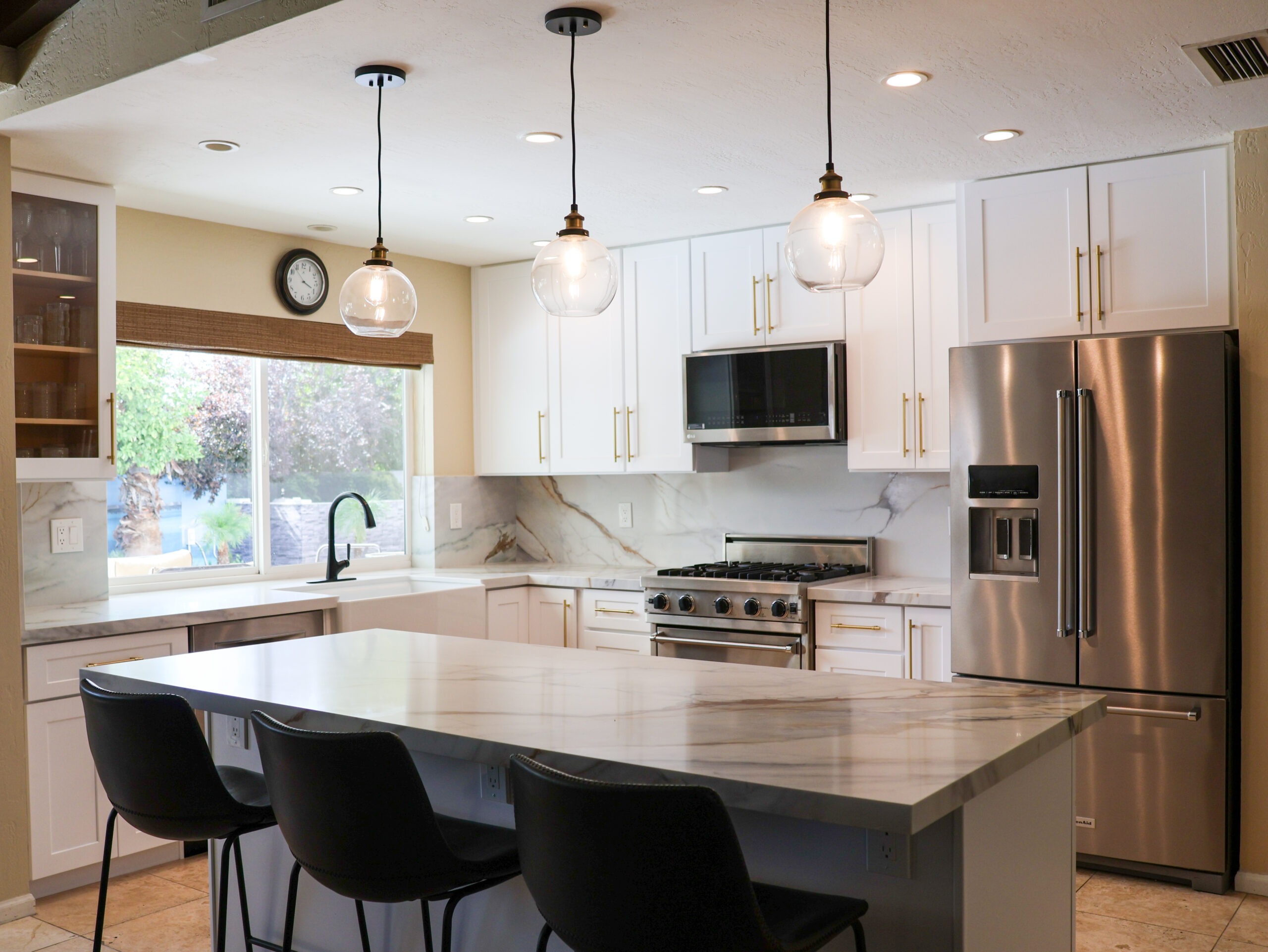 Remodeled kitchen with a marble island and pendant lights in a Scottsdale home by T26 Design Build